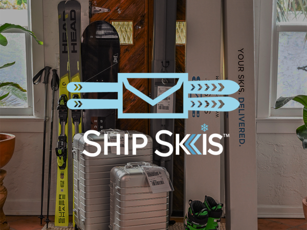 The image shows a set of skis, ski poles, luggage, and ski boots next to a 